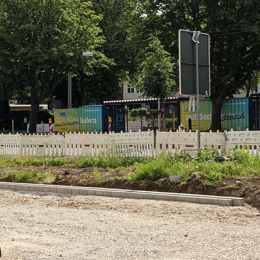 Baustelle des Radwegs am Wallring mit Blick auf das Mikrodepot in Dortmund mit verlegten Pflastersteinen als Begrenzung am Rand und Schotter in der Wegmitte