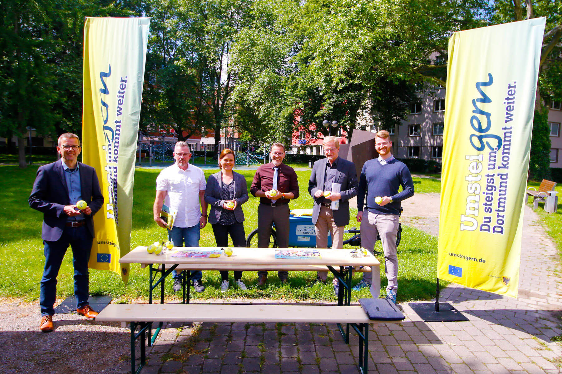Vertreter*innen der Stadt Dortmund und der Medien vor einem FestiWall-Tisch.